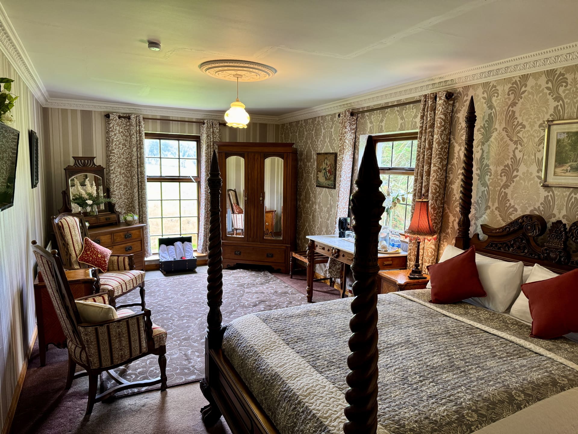 A four-poster bedroom with damask wallpaper
