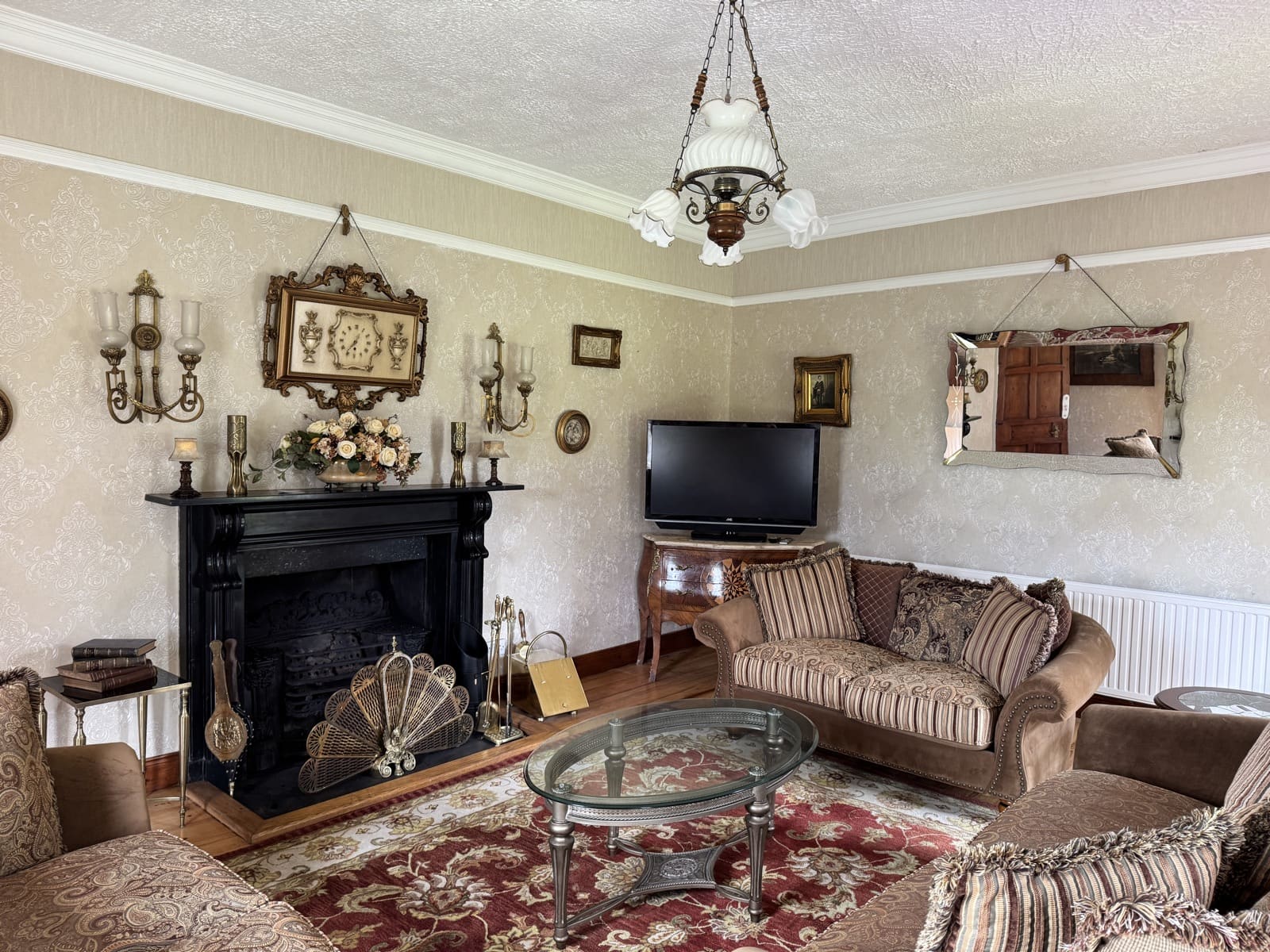 The drawing room at Cavangarden House — marble fireplace, antique furnishings, and views of the grounds