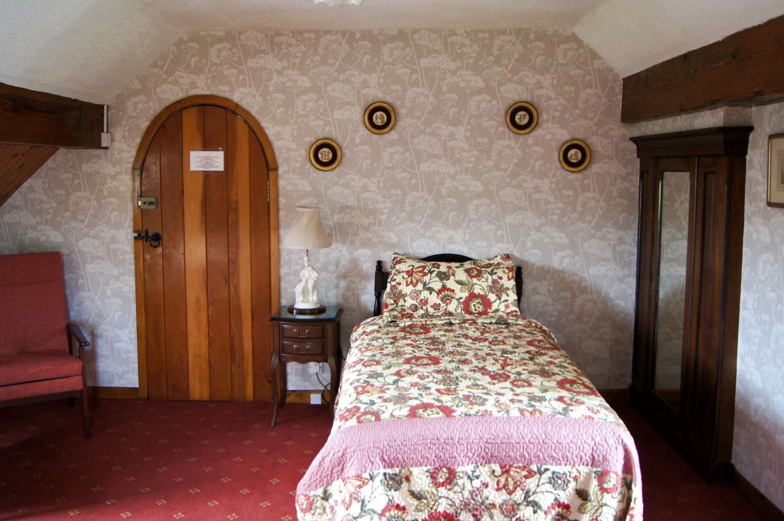 Triple Ensuite bed with floral bedding, timber door, and antique wardrobe