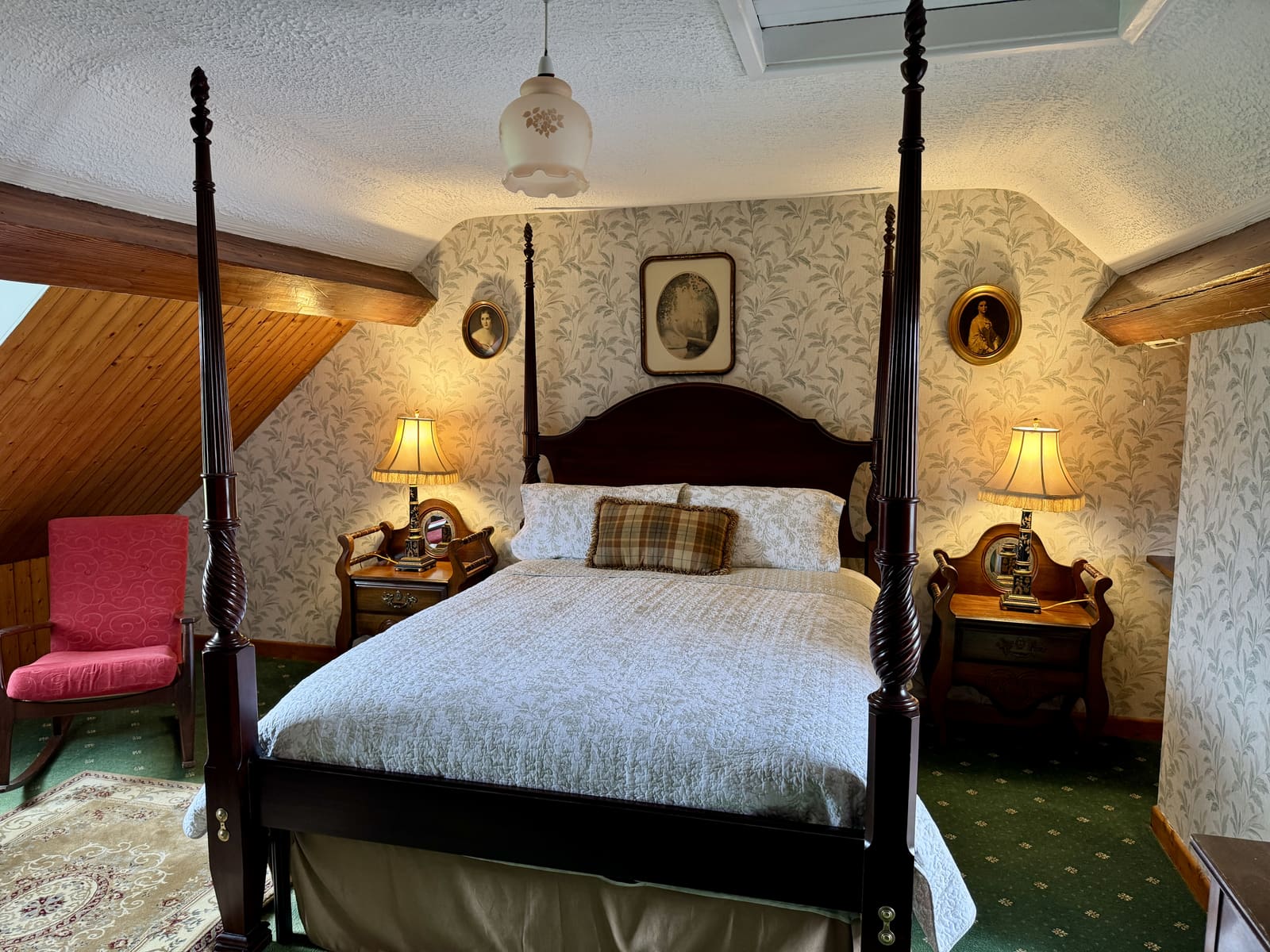 King Ensuite four-poster bed beneath sloped ceilings with warm bedside lamps