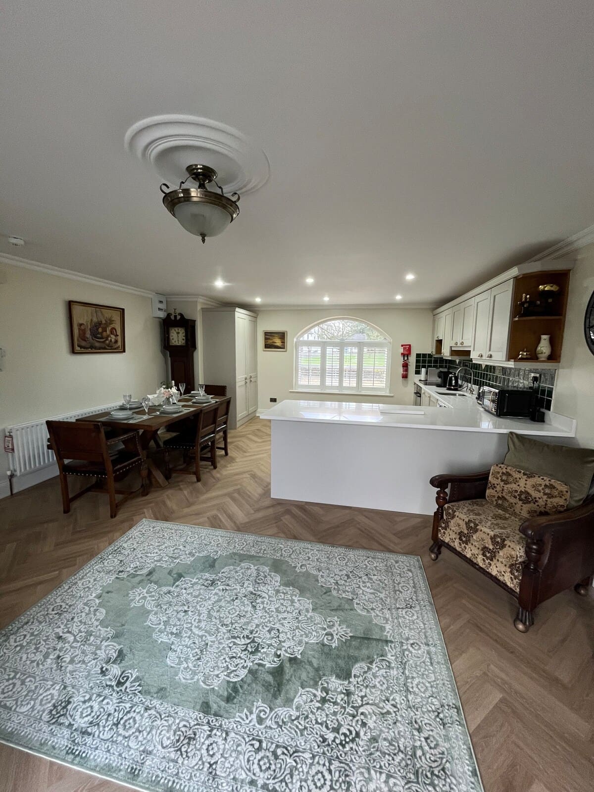 Open-plan kitchen, dining table, and living area with herringbone flooring