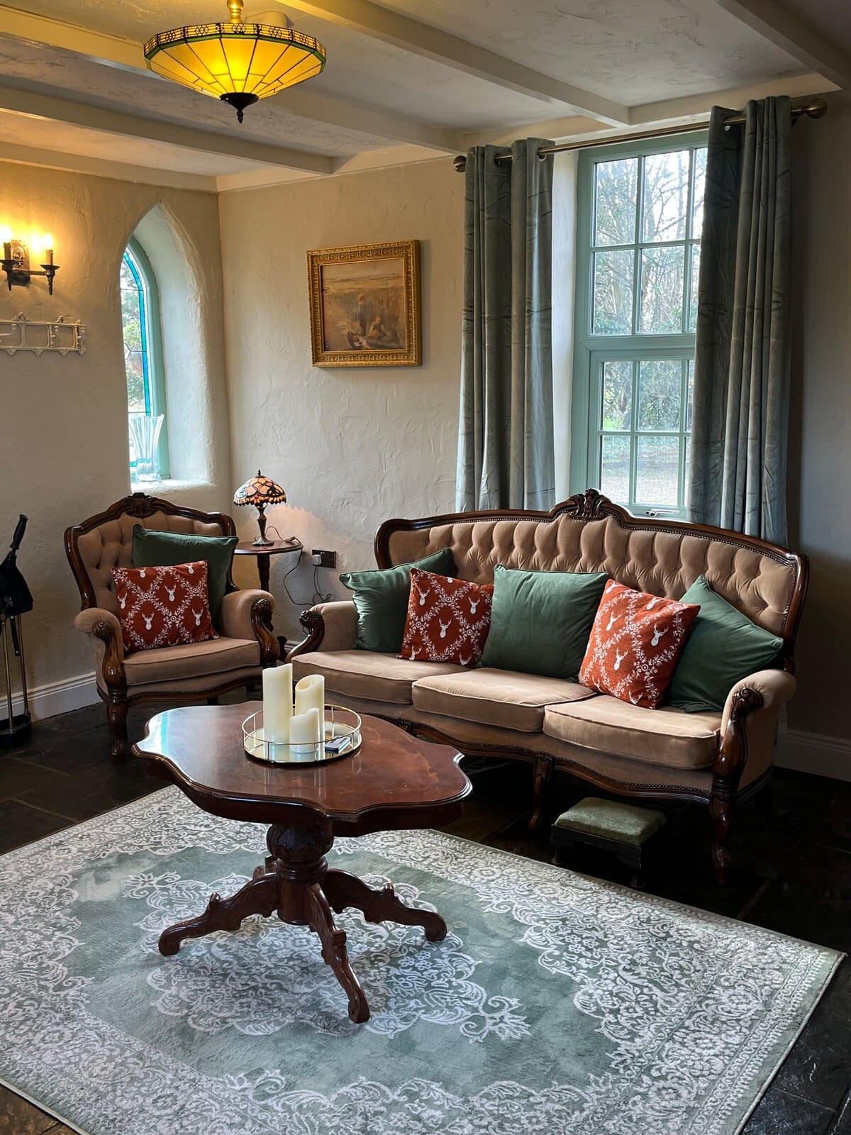 Cosy living room with tufted sofa, stained-glass lighting, and slate floors