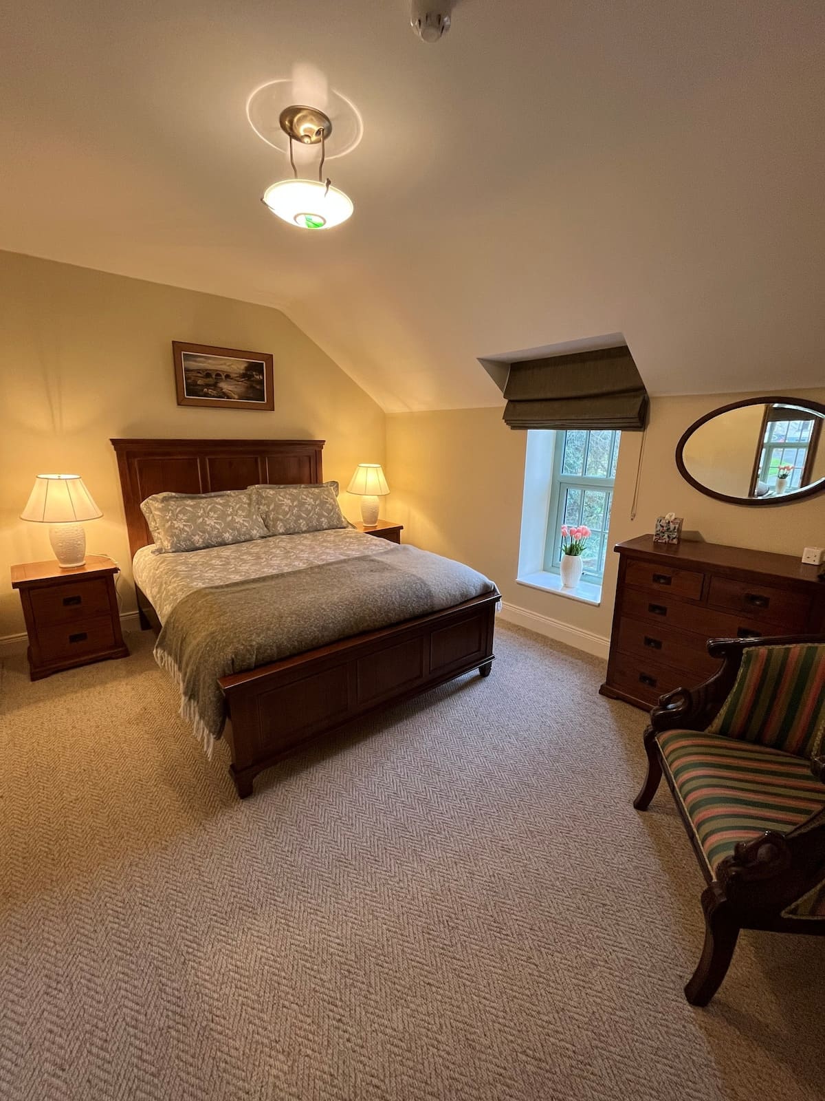 Bedroom with dark wood bed, floral bedding, and sloped ceiling